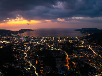 High angle view of illuminated cityscape against sky during sunset