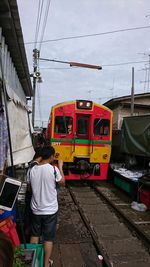 Rear view of train on railroad tracks against sky