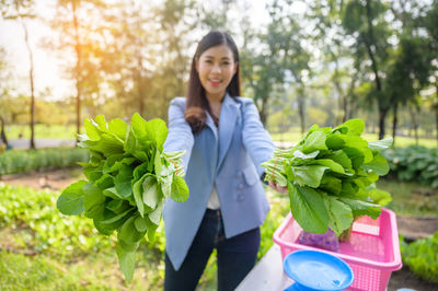 Portrait of woman holding plant