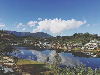 Scenic view of lake by buildings against sky