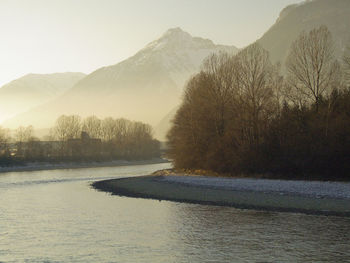 Scenic view of lake by mountains against sky