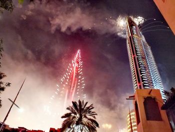 Low angle view of fireworks against sky at night