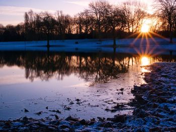 Scenic view of lake against sky at sunset