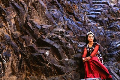 Portrait of young woman standing on rock