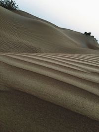 Sand dunes in desert against sky