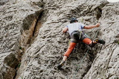 Rear view of man climbing on rock