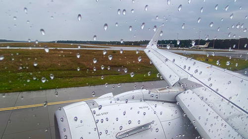 Airplane flying over wet glass window during rainy season