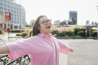 Happy teenage girl with down syndrome enjoying on footpath