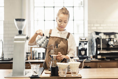 Female barista preparing coffee at counter