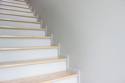 A white stairs with white wall on a house.