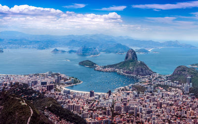 High angle view of sea and cityscape against sky