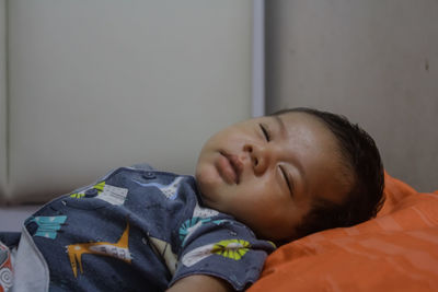 Portrait of boy sleeping on bed at home