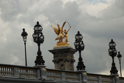 Low angle view of statue against cloudy sky