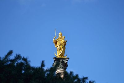 Low angle view of statue against blue sky