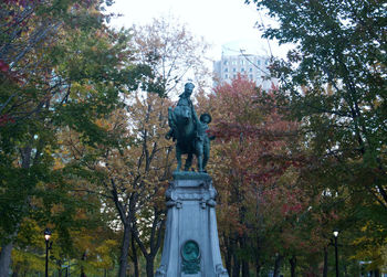 Low angle view of statue against trees