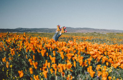 Low section of person wearing roller skating by blooming flowers