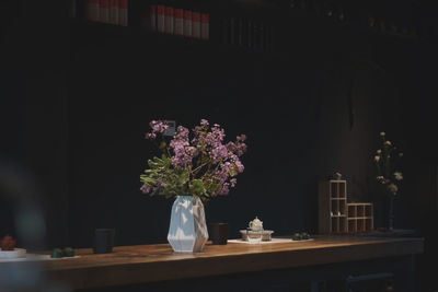 Flower vase on table against wall