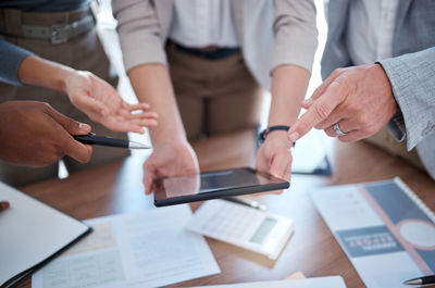 Midsection of business people working on table