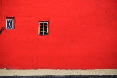 Red window on wall of building