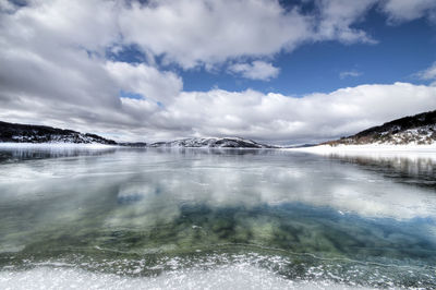 Scenic view of river against sky during winter