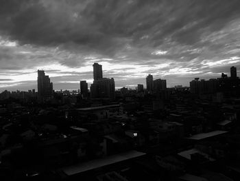 High angle view of city buildings against storm clouds