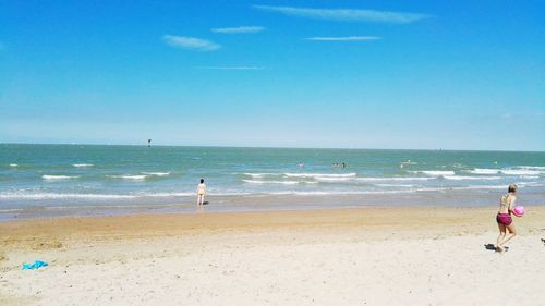 Rear view of man on beach against sky