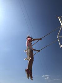 Low angle view of woman against blue sky