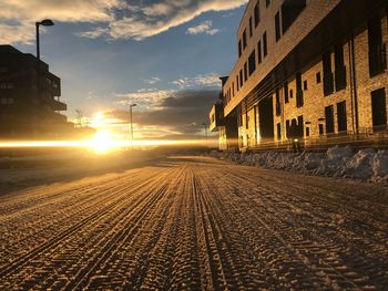 View of street amidst buildings in city during sunset