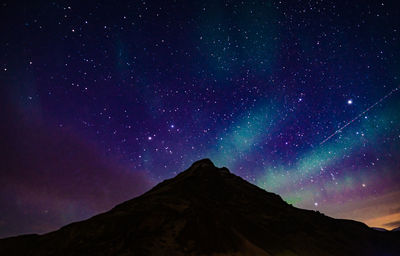 Low angle view of mountain against star field