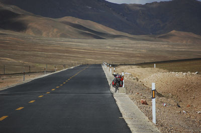 A flat newly built unmanned asphalt road leads to the front