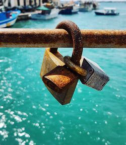 Close-up of padlocks on railing against river