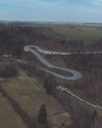 High angle view of road amidst field against sky