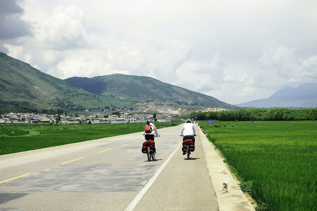 mountain, transportation, road, sky, rear view, the way forward, full length, land vehicle, mountain range, men, country road, walking, car, street, mode of transport, landscape, lifestyles, road marking