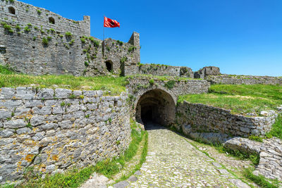 Stone wall with arms outstretched against sky