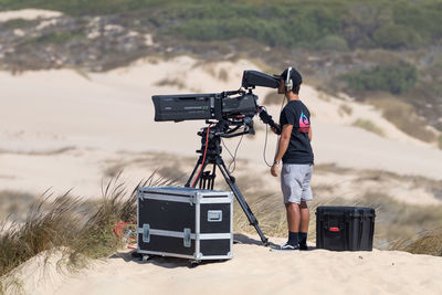 Man photographing on camera against sky