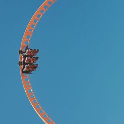 Low angle view of amusement park ride against clear sky