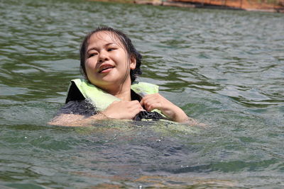 Portrait of a smiling woman swimming in sea