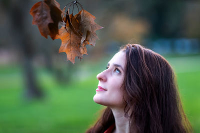 Close-up portrait of woman in autumn leaves