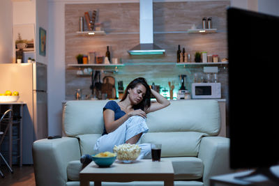 Portrait of young woman sitting at home