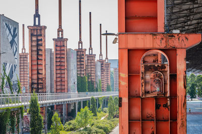 Buildings against sky seen through metal window