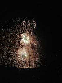 Low angle view of firework display at night