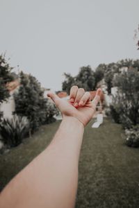 Close-up of woman hand against plants