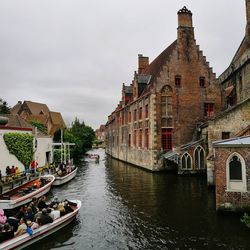 Canal amidst buildings in city against sky