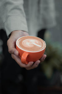 Close-up of hand holding coffee cup