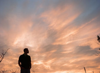 Rear view of silhouette man standing against sky