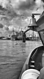 Cropped boat sailing in sea against cloudy sky