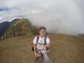 High angle portrait of happy woman holding monopod on mountain