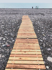 Surface level of footpath by sea against sky