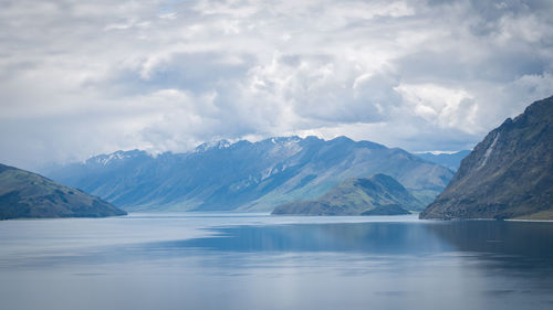 Scenic alpine lake surrounded by mountains shot on sunny day. location is lake hawea, new zealand