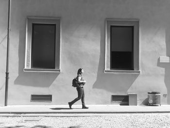 Full length of woman walking by building